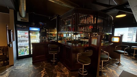 Dunkle Holztheke der Riff Raff Bar mit beleuchteter Flaschenauswahl